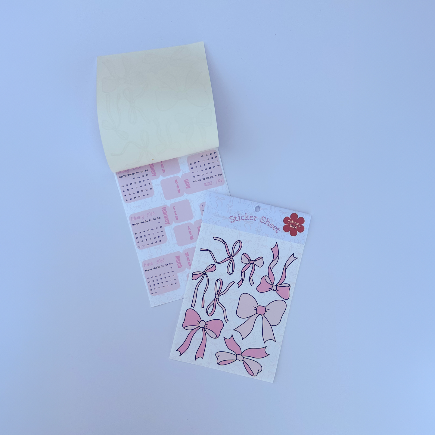 Set of pink bow-shaped stickers on a white card against a white background