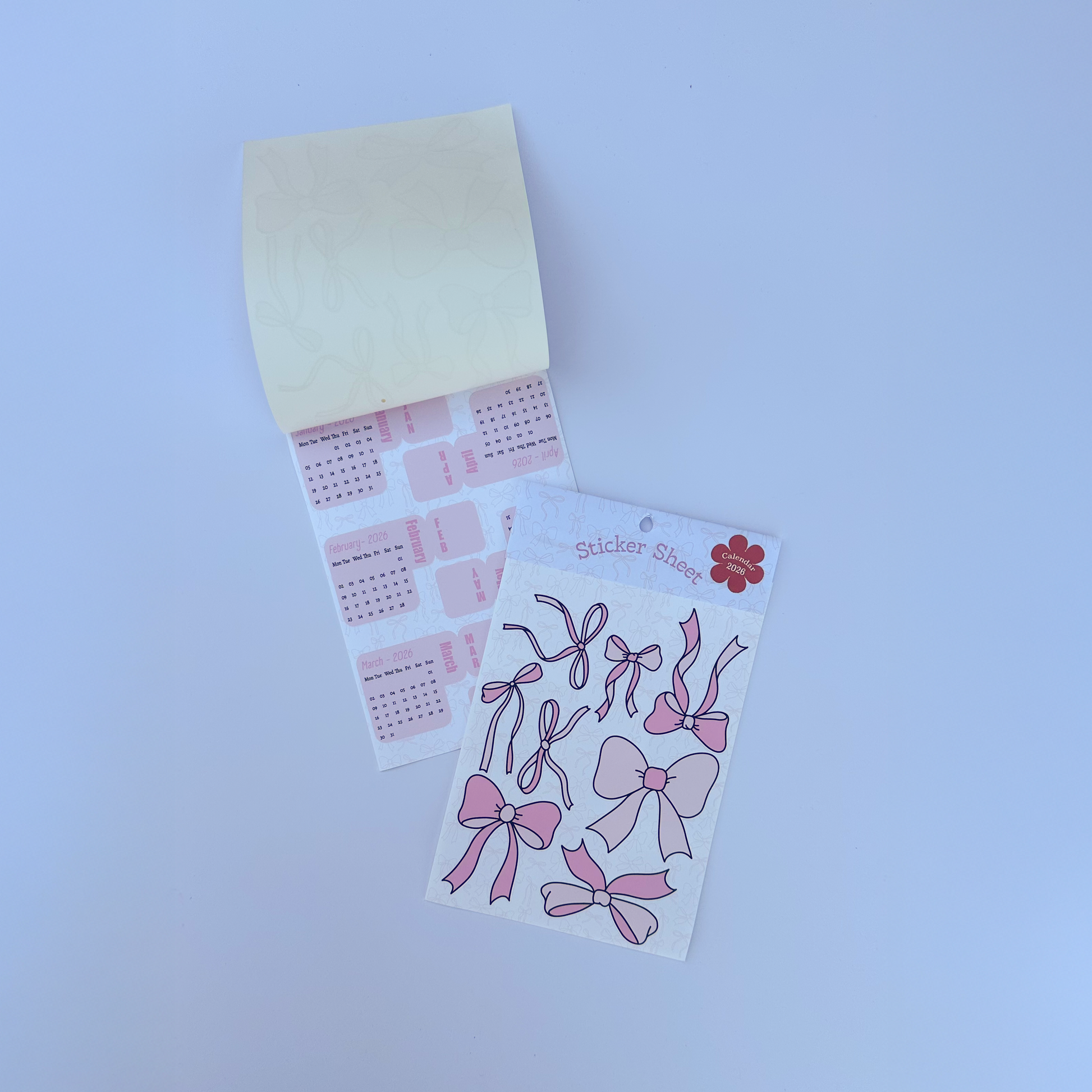Set of pink bow-shaped stickers on a white card against a white background