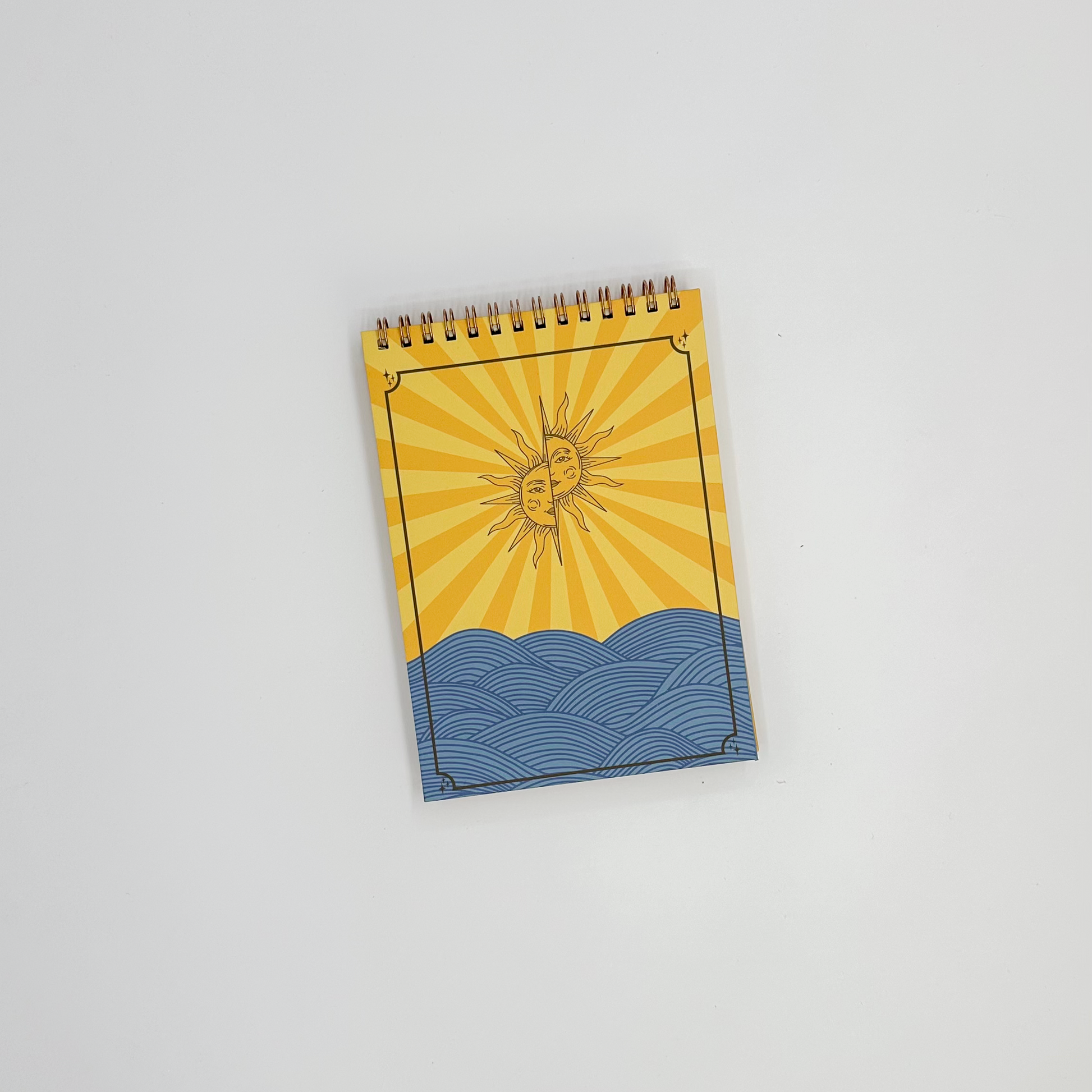 Notepad with sun and wave design on a white background