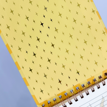 Notepad with star pattern on yellow cover against a light blue background
