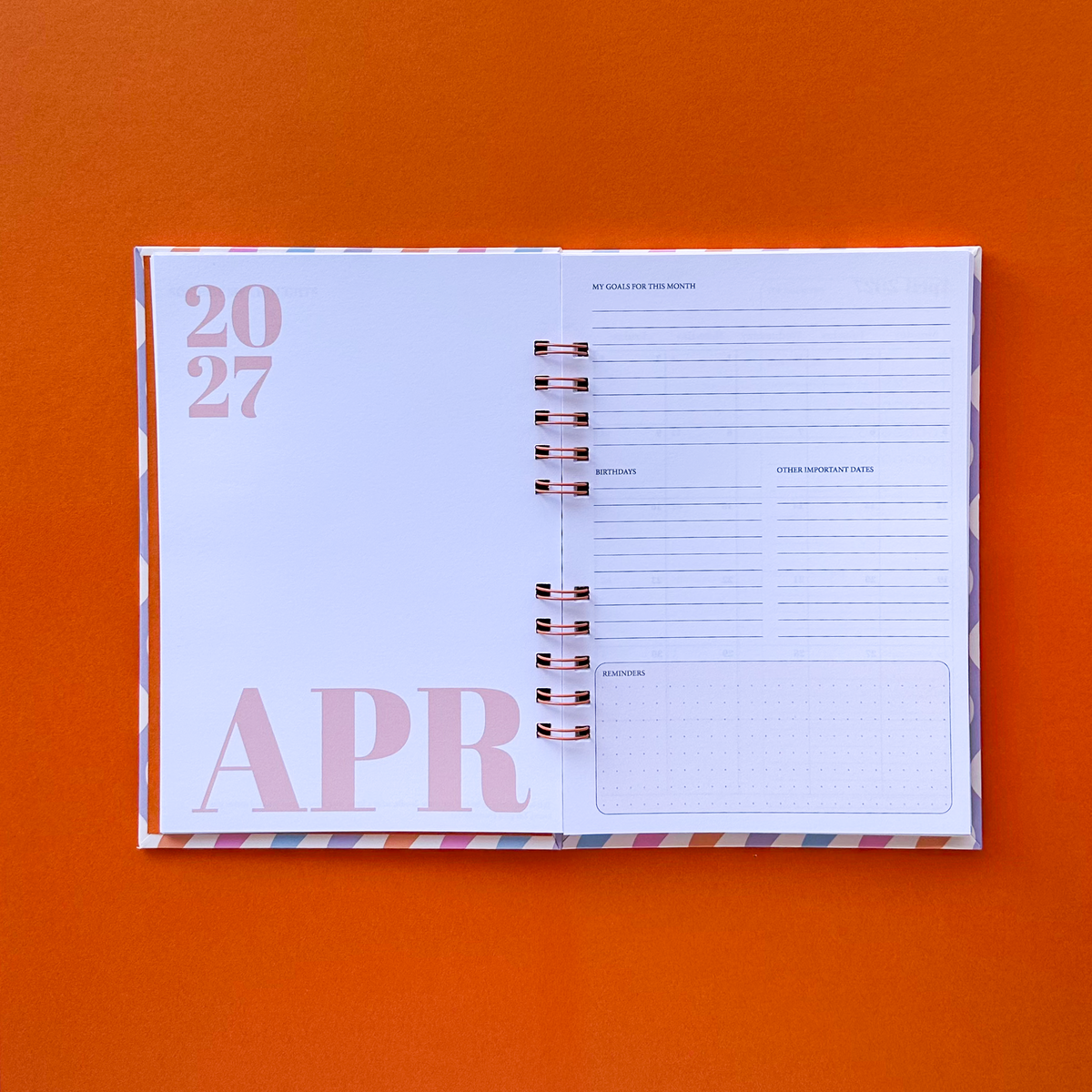 Open page planner showing with April page on the left and lined page on the right in a orange background