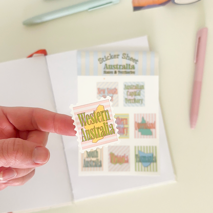 Hand holding a sticker from a sticker sheet with 8 different stickers with australian's states and territories in a vintage design with soft colours