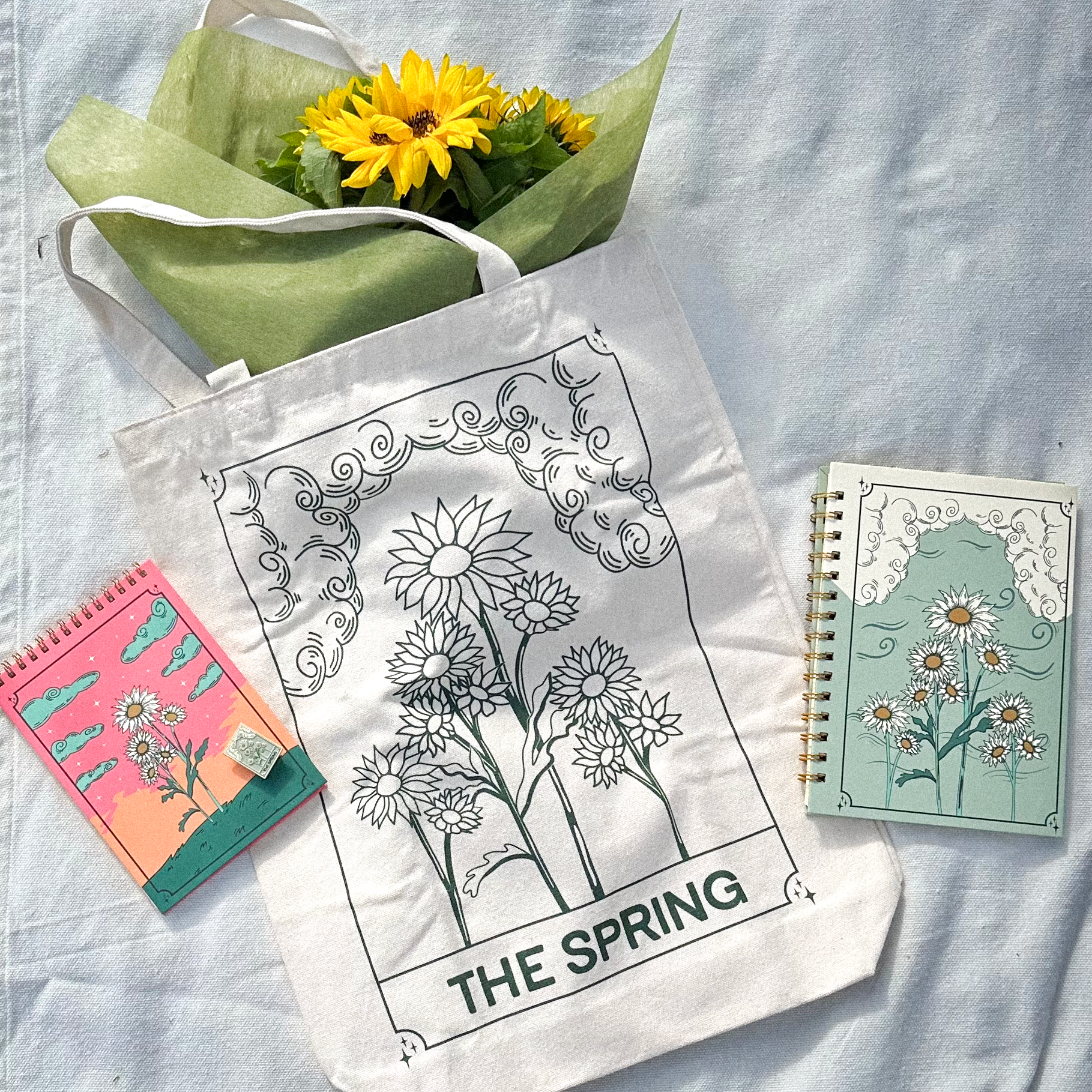 photo showing tote bag, notepad, notebook with sunflower