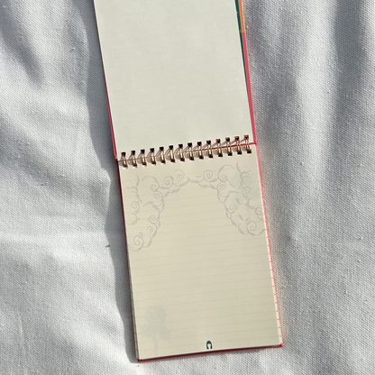 Spring notepad showing flower design in a light beige towel and polaroid and pens