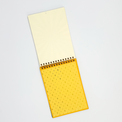 Yellow spiral-bound back inside cover of notepad on a white background