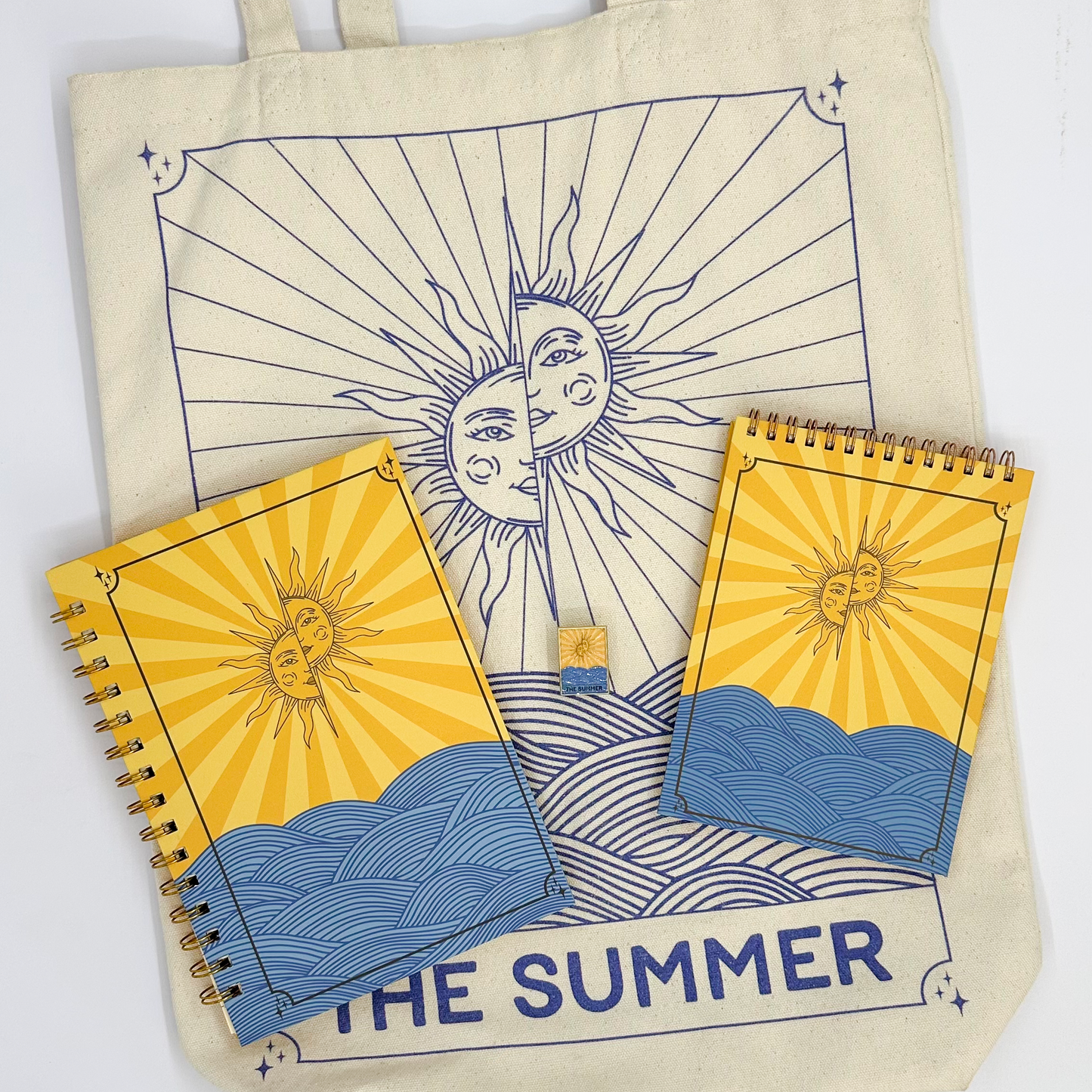 Tote bag and notebooks with sun and moon design, featuring 'The Summer' text.