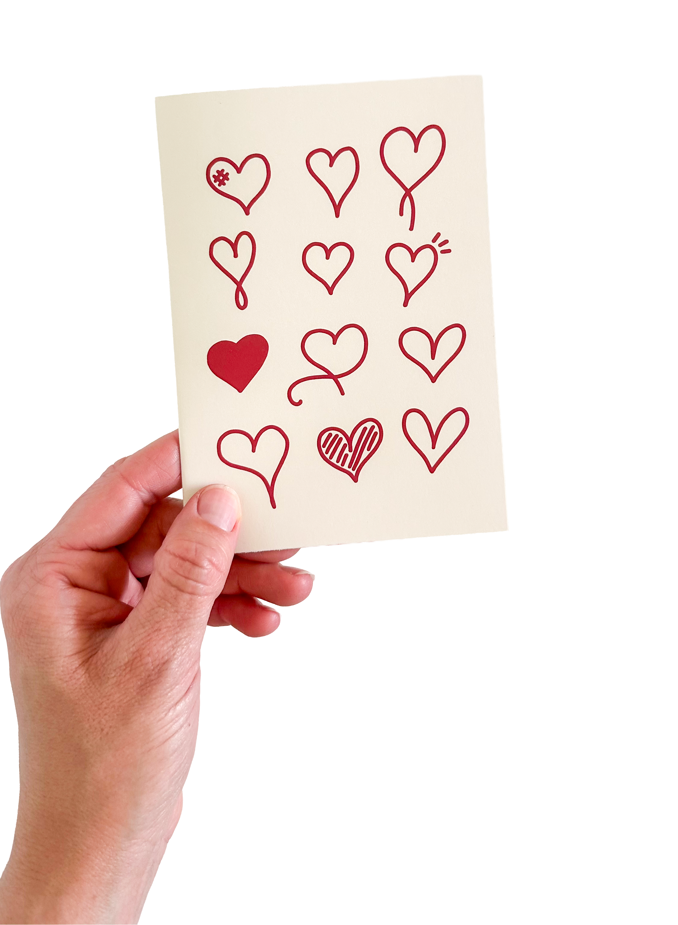 Hand holding a card with red heart designs on a white background