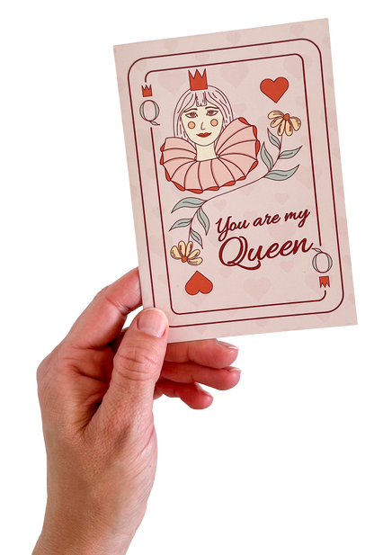 Hand holding a card with a queen of hearts illustration and text 'You are my queen' on a white background